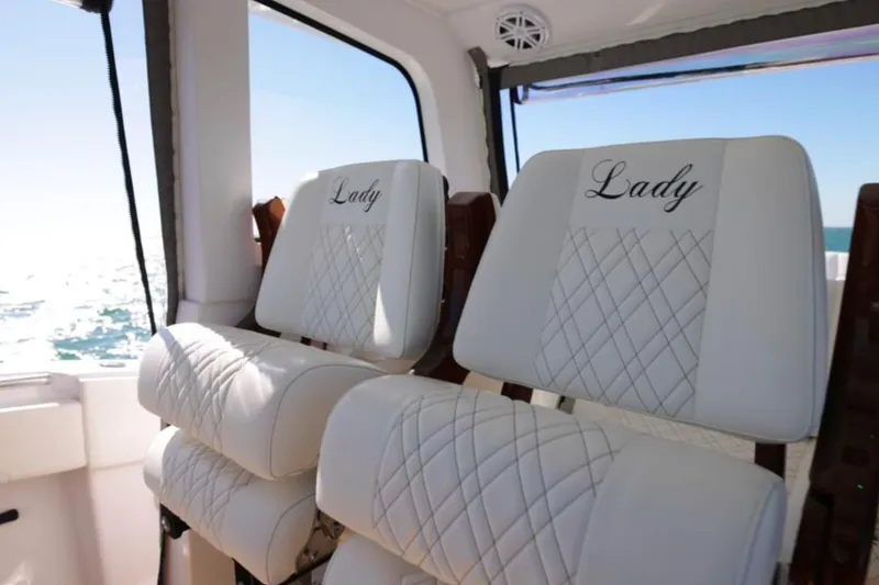 Slide: The Image of Luxurious white seats on a 2025 Century NAV4100 CC-H boat, embroidered with "Lady." - 36