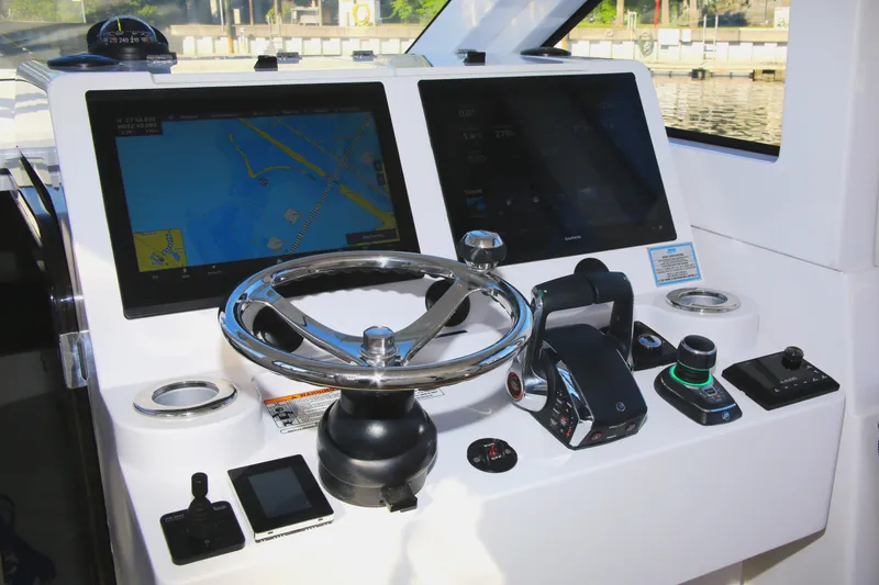 Slide: The Image of Control panel of 2025 Century NAV4100 CC-H boat with navigation screens and steering wheel. - 37
