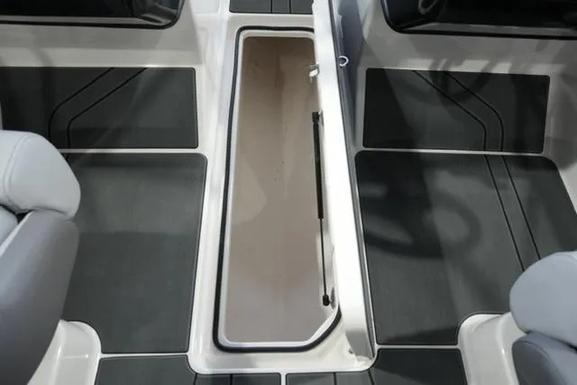 Slide: The Image of 2025 Bayliner V20i boat interior with open storage compartment and sleek seating. - 13