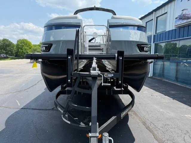 Slide: The Image of 2025 Harris Grand Mariner 250 pontoon boat on trailer, parked outside a building. - 2