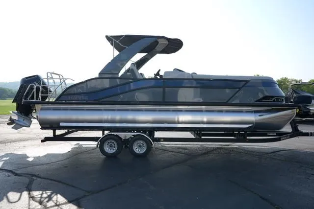 Slide: The Image of 2025 Harris Grand Mariner 250 pontoon boat on trailer, sleek design, outdoor setting. - 20