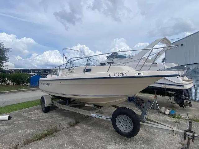 Slide: The Image of Key West 2020 Walkaround boat on trailer, parked outdoors, cloudy sky background. - 5