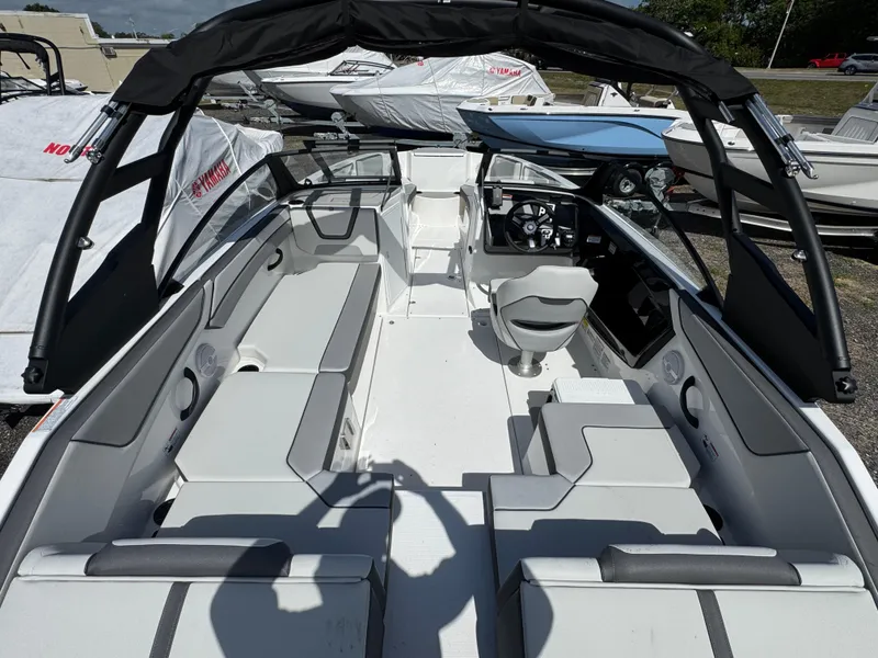Slide: The Image of 2025 Yamaha Boats AR220 interior with seating and steering wheel, displayed outdoors. - 3