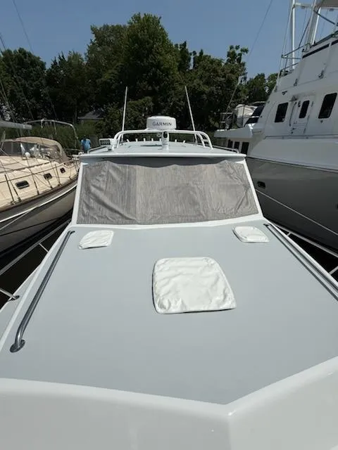 Slide: The Image of 2004 Mabry 40 boat docked among other vessels, featuring a sleek design and covered windows. - 1