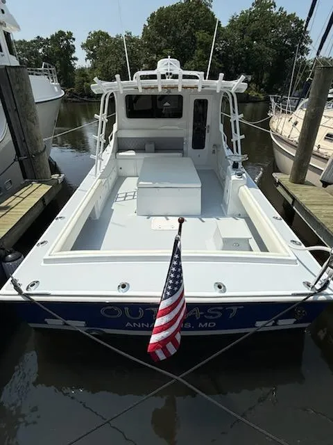 Slide: The Image of 2004 Mabry 40 boat docked, displaying American flag, surrounded by trees and other boats. - 14