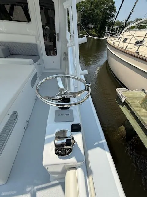 Slide: The Image of Steering console of a 2004 Mabry 40 boat docked beside another vessel. - 18