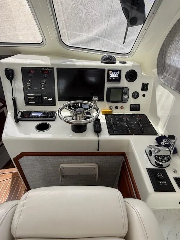 Slide: The Image of Control panel of a 2004 Mabry 40 boat with steering wheel and navigation instruments. - 23