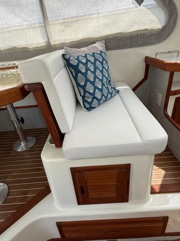 Slide: The Image of White cushioned seating with blue patterned pillow on 2004 Mabry 40 boat interior. - 27