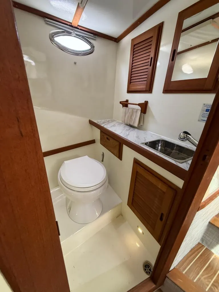 Slide: The Image of Compact bathroom in 2004 Mabry 40 boat with wooden accents and porthole window. - 33