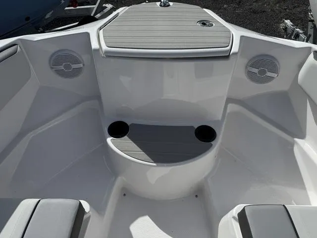 Slide: The Image of 2025 Yamaha Boats AR220 bow seating area with cup holders and speakers. - 11
