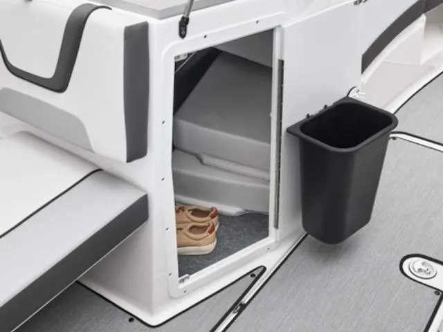 Slide: The Image of 2025 Yamaha AR220 boat interior storage compartment with shoes and trash bin. - 30