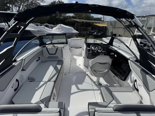 Slide: The Image of 2025 Yamaha Boats AR220 interior with sleek seating and modern dashboard under a sunny sky. - 4