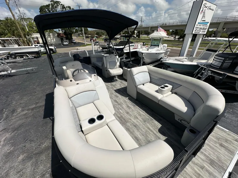 Slide: The Image of 2022 Crest Classic DLX 220 pontoon boat with spacious seating and canopy, displayed outdoors. - 10
