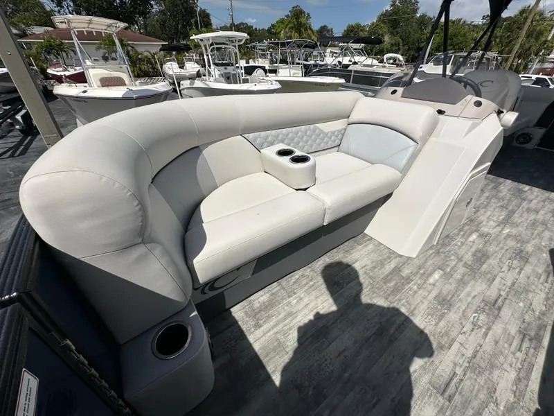 Slide: The Image of 2022 Crest Classic DLX 220 boat interior with cushioned seating and cup holders. - 13