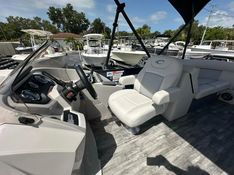 Slide: The Image of 2022 Crest Classic DLX 220 boat interior with steering wheel and comfortable seating. - 16