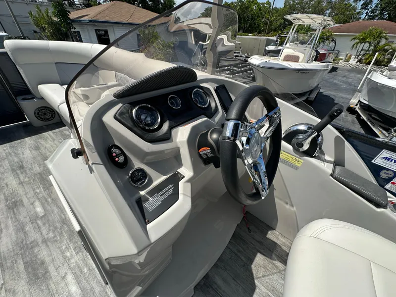 Slide: The Image of 2022 Crest Classic DLX 220 boat dashboard with steering wheel and controls. - 17