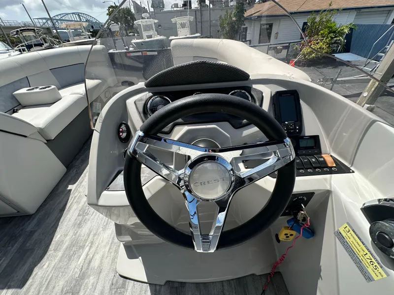Slide: The Image of 2022 Crest Classic DLX 220 boat steering console with modern controls and sleek design. - 18