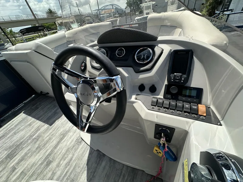 Slide: The Image of 2022 Crest Classic DLX 220 boat dashboard with steering wheel and control panel. - 19