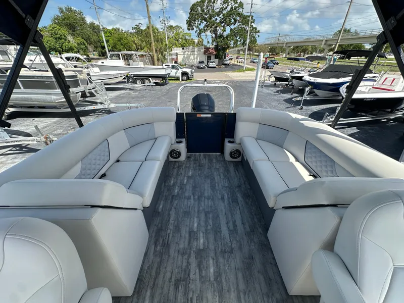 Slide: The Image of 2022 Crest Classic DLX 220 pontoon boat with spacious seating and modern design. - 20