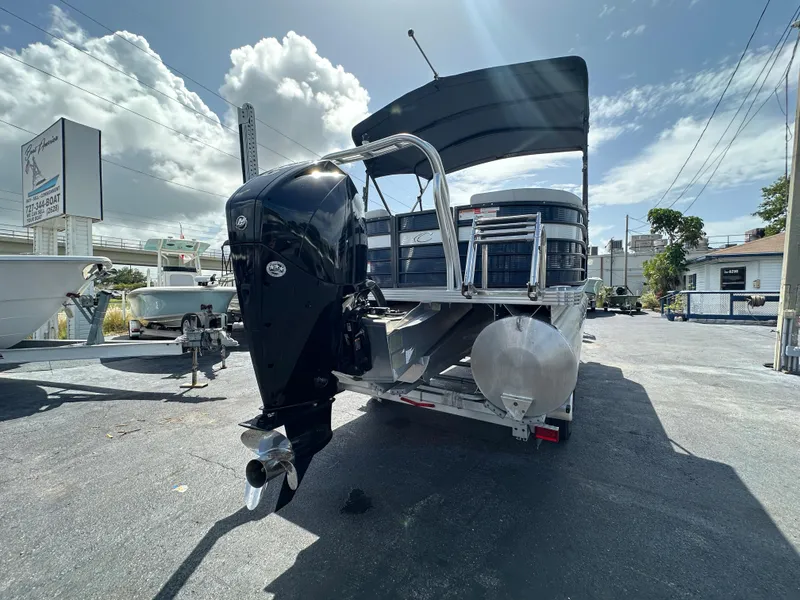 Slide: The Image of 2022 Crest Classic DLX 220 pontoon boat with outboard motor, parked outdoors. - 3