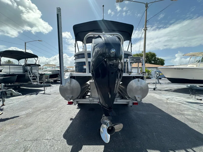 Slide: The Image of 2022 Crest Classic DLX 220 pontoon boat with powerful outboard motor, parked under clear sky. - 4