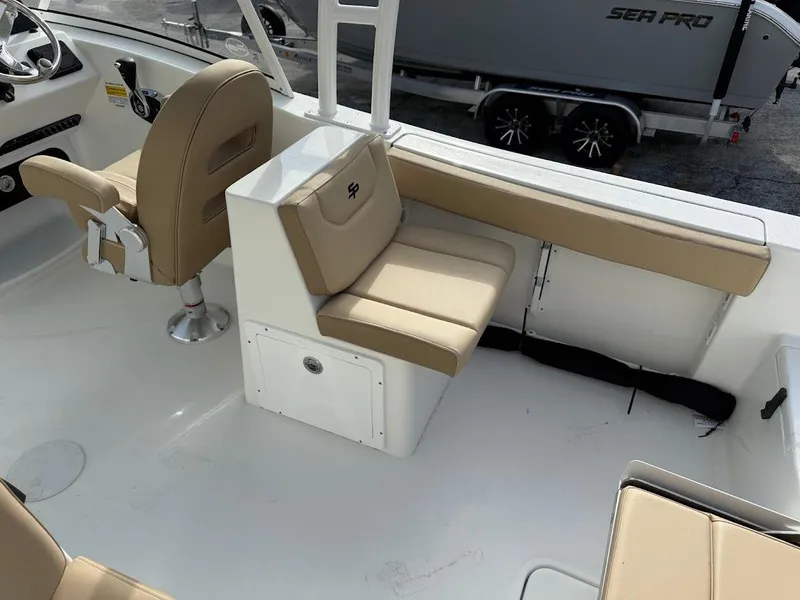 Slide: The Image of 2025 Sea Pro 240 Dual Console boat interior with beige seating and white deck. - 11
