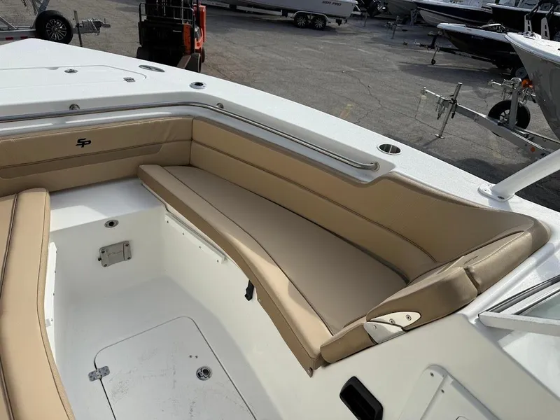 Slide: The Image of 2025 Sea Pro 240 Dual Console boat with beige seating in a marina setting. - 17