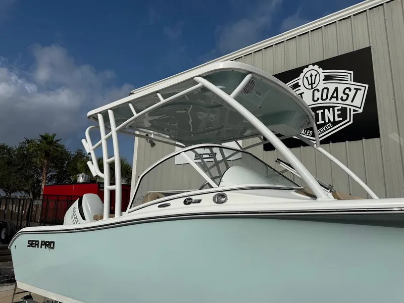 Slide: The Image of 2025 Sea Pro 240 Dual Console boat with T-top, displayed outdoors. - 2