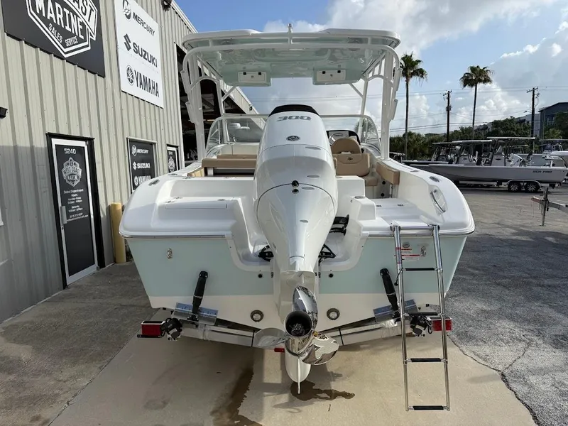 Slide: The Image of 2025 Sea Pro 240 Dual Console boat with powerful outboard motor, docked at a marina. - 6