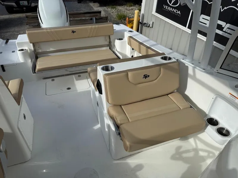Slide: The Image of 2025 Sea Pro 240 Dual Console boat interior with beige seating and cup holders. - 9