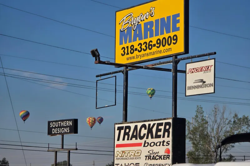 Slide: The Image of Signage for Bryan's Marine and Tracker Boats with hot air balloons in the background. - 8