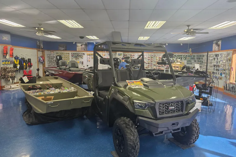 Slide: The Image of Store interior showcasing a 2025 Tracker Pro Team 175 boat and off-road vehicle. - 9