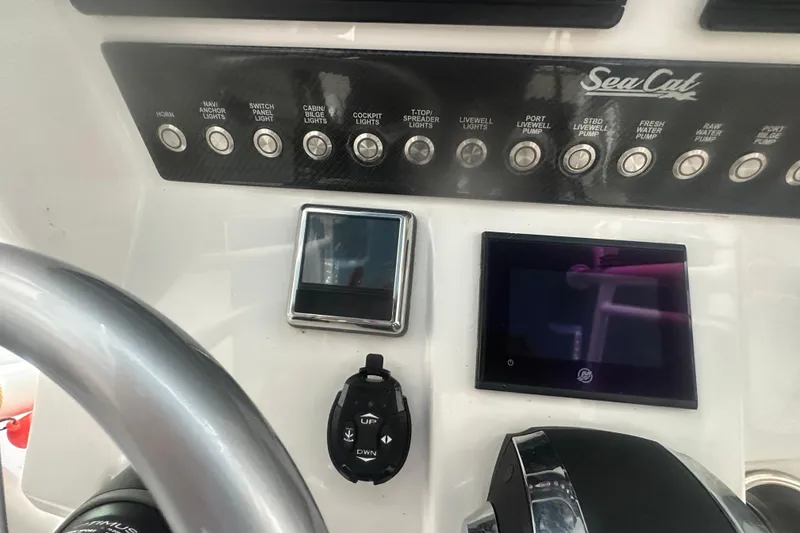 Slide: The Image of Control panel of a 2021 Sea Cat 260 boat with various switches and displays. - 10