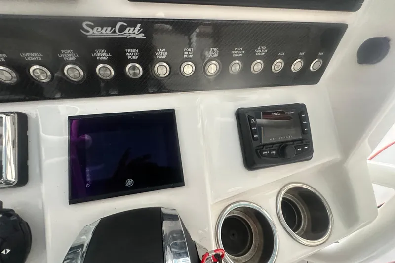 Slide: The Image of Control panel of a 2021 Sea Cat 260 boat with switches and display. - 11