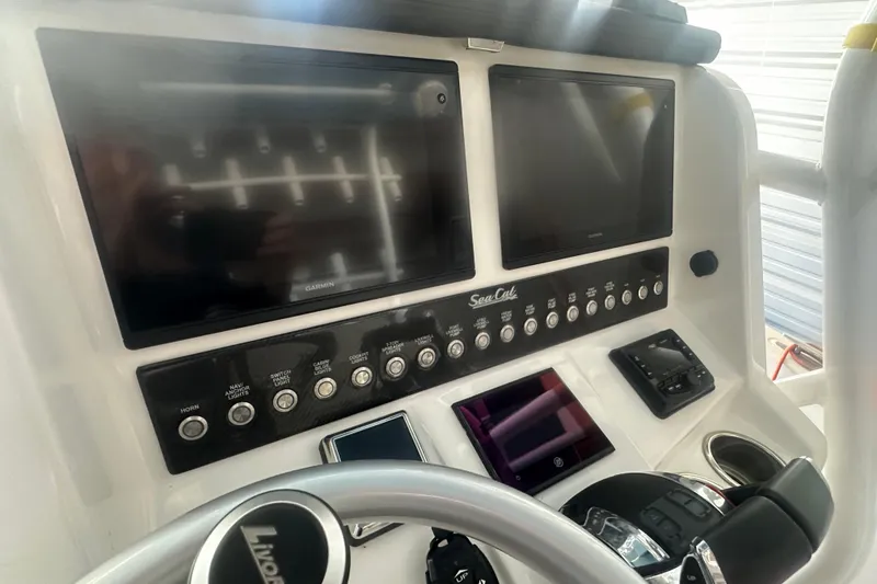 Slide: The Image of Control panel of a 2021 Sea Cat 260 boat with Garmin displays and switches. - 12