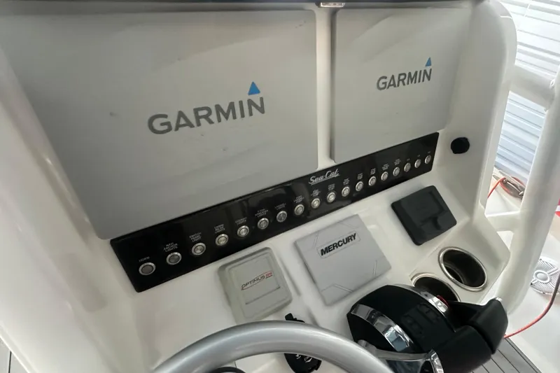Slide: The Image of Control panel of 2021 Sea Cat 260 boat featuring Garmin displays and Mercury controls. - 13