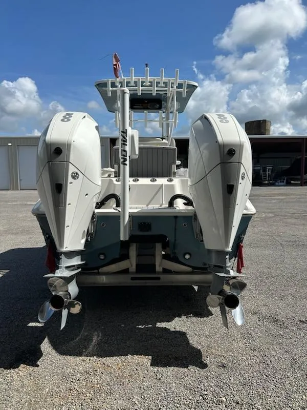 Slide: The Image of 2021 Sea Cat 260 boat with dual outboard motors, parked outdoors under a cloudy sky. - 2