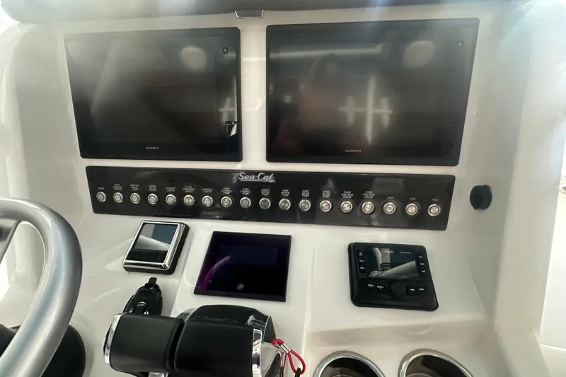 Slide: The Image of Control panel of a 2021 Sea Cat 260 boat with Garmin displays and switches. - 9