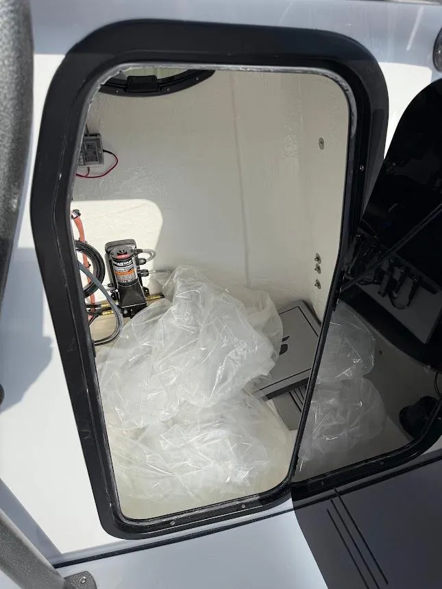 Slide: The Image of 2025 Sea Pro 230 Bay boat storage compartment with wiring and equipment. - 11