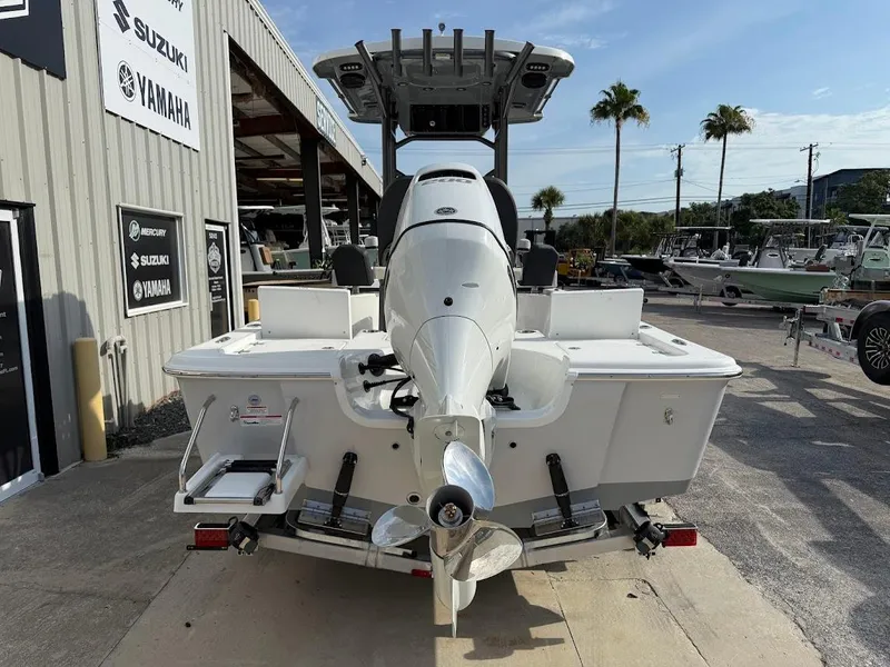 Slide: The Image of 2025 Sea Pro 230 Bay boat, rear view, parked at a marina with palm trees. - 8