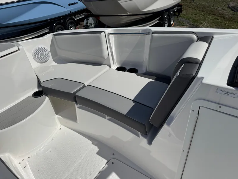 Slide: The Image of 2025 Yamaha Boats AR220 interior seating with cup holders and speaker. - 8