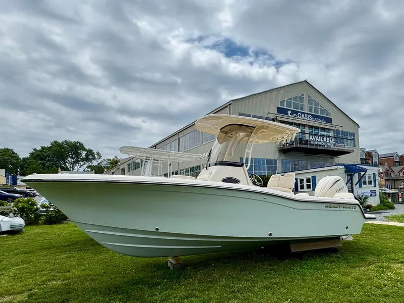 The Image of 2025 Grady-White Fisherman 216 boat displayed outdoors near a marina building. - 1