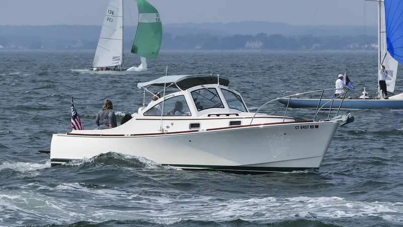 The Image of 2008 Landing School Arundel 27 boat cruising on open water with sailboats in the background. - 0