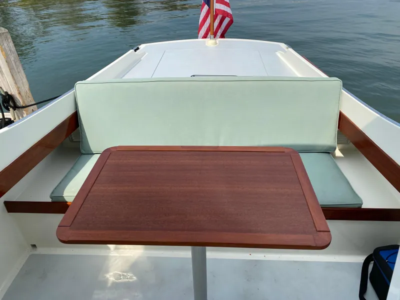 Slide: The Image of 2008 Landing School Arundel 27 boat interior with wooden table and cushioned seating. - 10