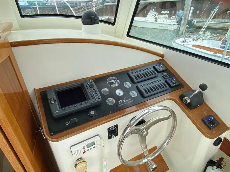 Slide: The Image of Control panel of 2008 Landing School Arundel 27 boat with navigation equipment and steering wheel. - 15