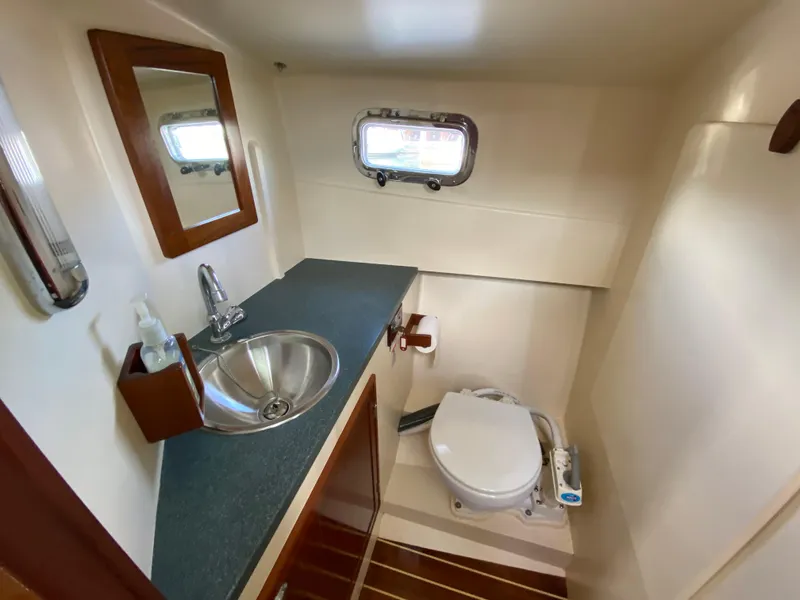 Slide: The Image of Compact bathroom in 2008 Landing School Arundel 27 boat, featuring sink, toilet, and porthole. - 16