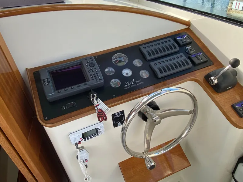 Slide: The Image of Control panel of a 2008 Landing School Arundel 27 boat with steering wheel and navigation equipment. - 20