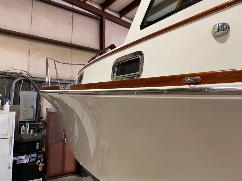 Slide: The Image of 2008 Landing School Arundel 27 boat in storage, showcasing sleek hull and polished wood trim. - 25