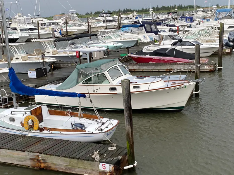 Slide: The Image of 2008 Landing School Arundel 27 docked among various boats at a marina. - 8