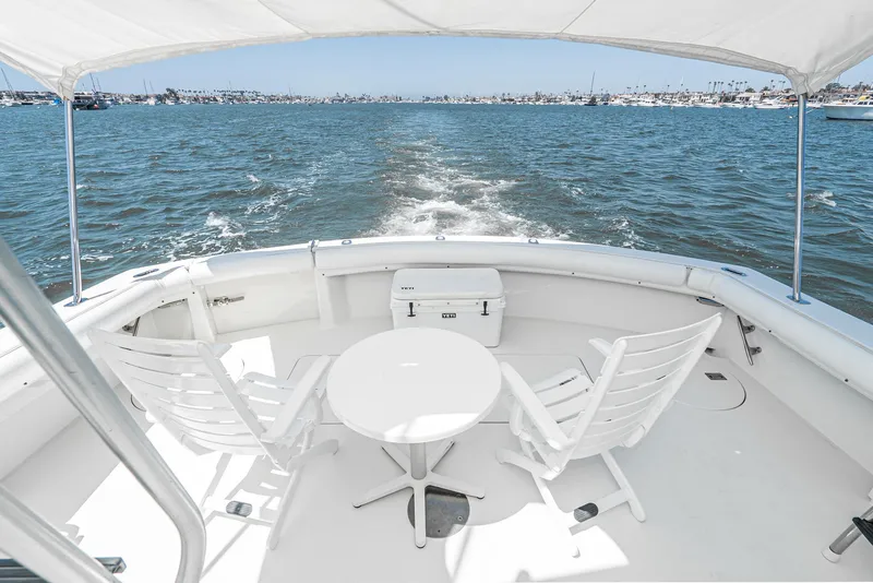 Slide: The Image of 1990 Hatteras 58 Sportfish yacht deck with chairs, table, and ocean view. - 18